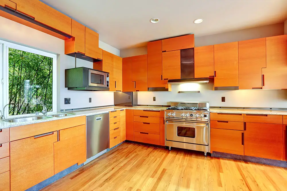 Kitchen with tangerine cabinets steel appliances